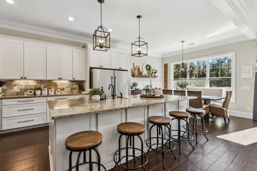 kitchen featuring backsplash, stainless steel fridge, white cabinetry, and ornamental molding