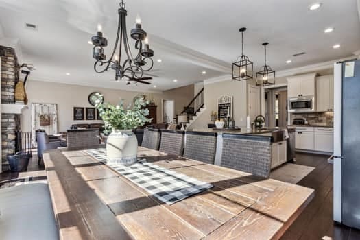 dining area with a chandelier, recessed lighting, stairs, and dark wood-style flooring