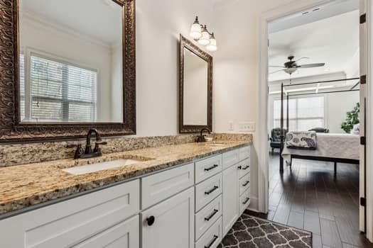 full bathroom with double vanity, wood finished floors, a ceiling fan, and a sink