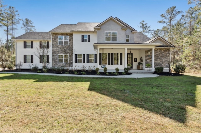 view of front facade with stone siding, a porch, and a front yard