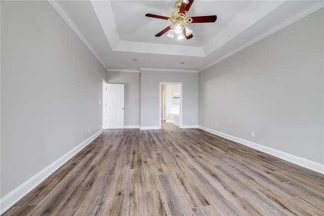 unfurnished bedroom featuring a raised ceiling, ceiling fan, light hardwood / wood-style flooring, and ornamental molding