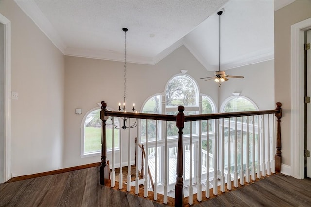 hall with dark hardwood / wood-style flooring, a textured ceiling, crown molding, a notable chandelier, and lofted ceiling