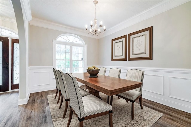 dining room with crown molding, dark hardwood / wood-style flooring, and a notable chandelier