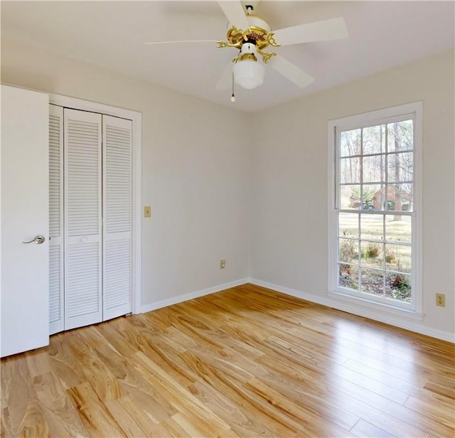 unfurnished bedroom with multiple windows, light hardwood / wood-style flooring, and a closet