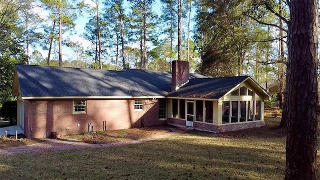 back of house featuring a yard and a sunroom