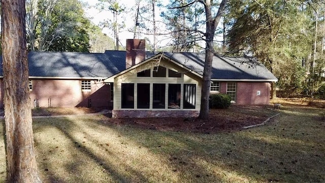 back of house with a sunroom and a yard