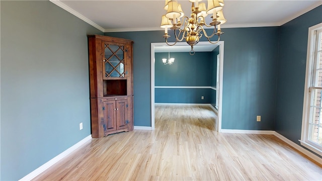 unfurnished dining area featuring an inviting chandelier, ornamental molding, and light hardwood / wood-style flooring