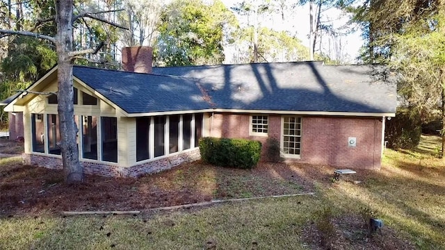 exterior space featuring a lawn and a sunroom