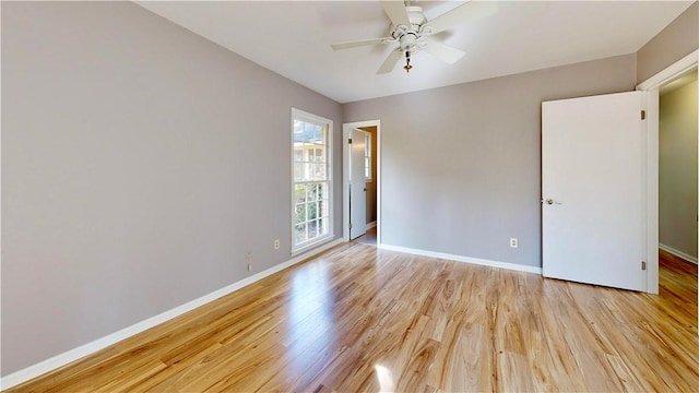 empty room with ceiling fan and light hardwood / wood-style flooring