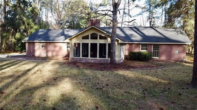 view of front facade with a sunroom and a front lawn