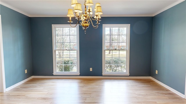 empty room with crown molding, a wealth of natural light, and light hardwood / wood-style flooring