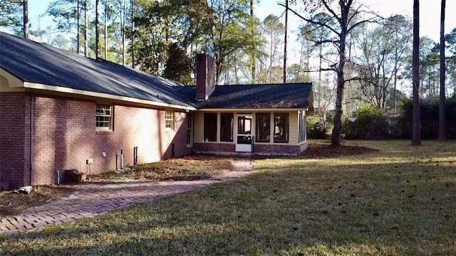 rear view of house featuring a yard