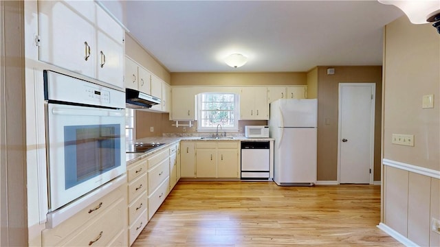 kitchen with sink, white appliances, and light hardwood / wood-style flooring