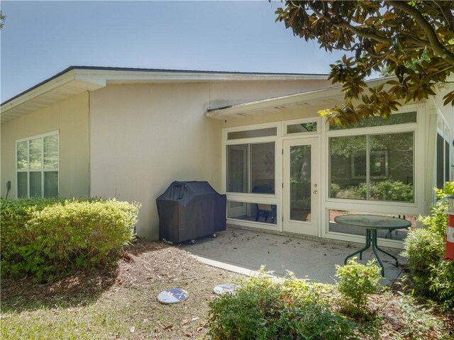 130 Peppertree Crossing Ave, Brunswick, GA 31525 - rear view of property featuring stucco siding, a patio area, and a sunroom