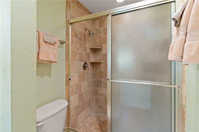 bathroom featuring toilet and a stall shower
