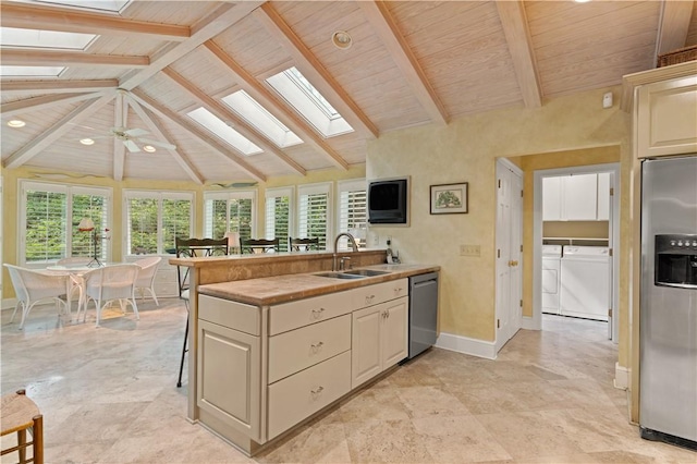 kitchen with wood ceiling, independent washer and dryer, a sink, and appliances with stainless steel finishes