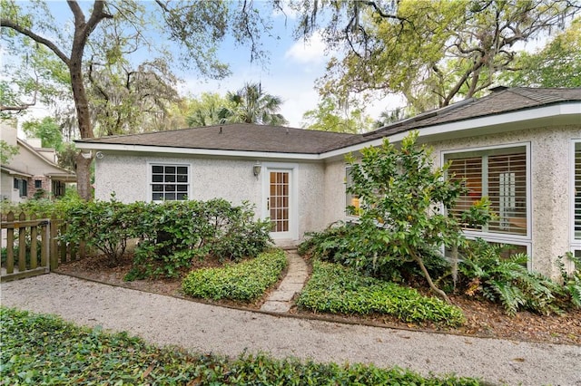 view of front of property with stucco siding and fence
