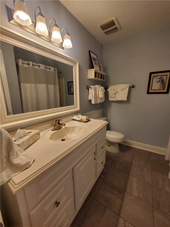 bathroom with toilet, tile patterned flooring, and vanity