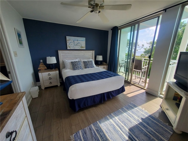 bedroom featuring dark hardwood / wood-style flooring, access to exterior, ceiling fan, and expansive windows