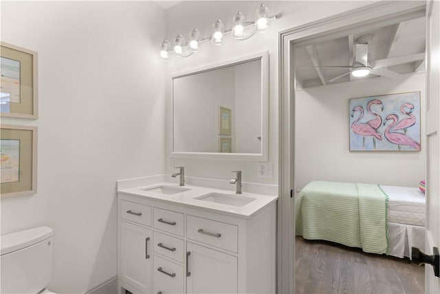 bathroom with hardwood / wood-style floors, vanity, toilet, and ceiling fan