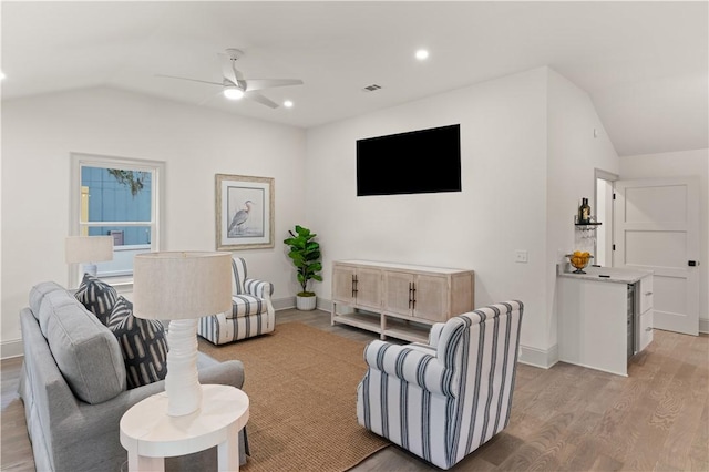 living room featuring light hardwood / wood-style flooring, ceiling fan, and lofted ceiling