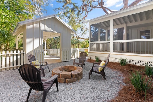 view of patio / terrace featuring a sunroom and a fire pit