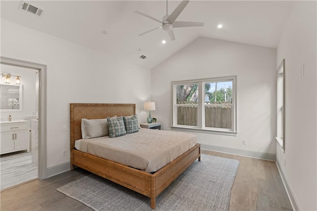 bedroom with vaulted ceiling, light hardwood / wood-style flooring, ensuite bath, and ceiling fan