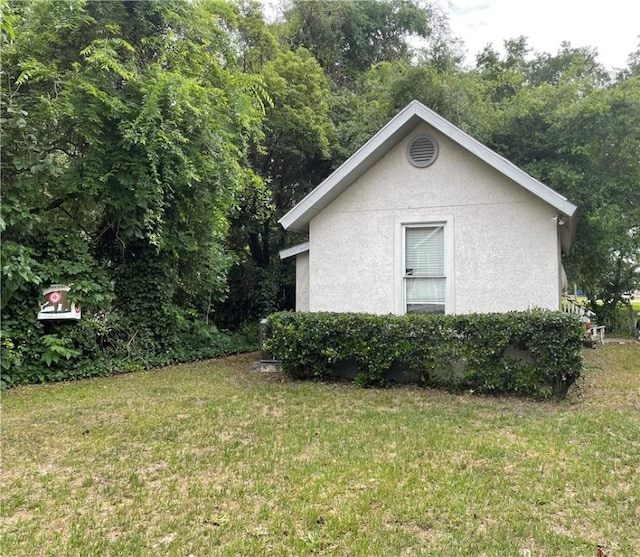 725 Grant St, Brunswick, GA 31520 - view of property exterior featuring stucco siding and a lawn