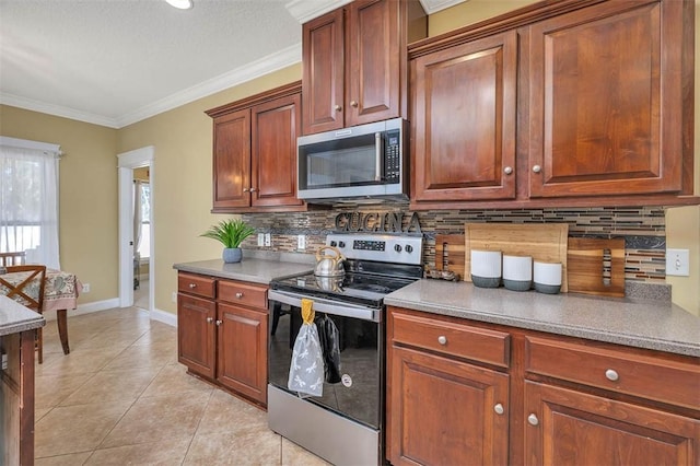 43 Coral Cv, Brunswick, GA 31523 - kitchen featuring stainless steel appliances, ornamental molding, decorative backsplash, light tile patterned flooring, and baseboards