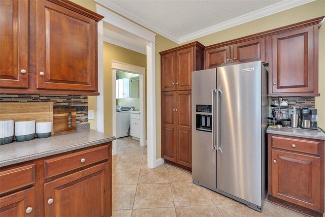 43 Coral Cv, Brunswick, GA 31523 - kitchen featuring stainless steel fridge with ice dispenser, backsplash, ornamental molding, light tile patterned flooring, and washer / dryer