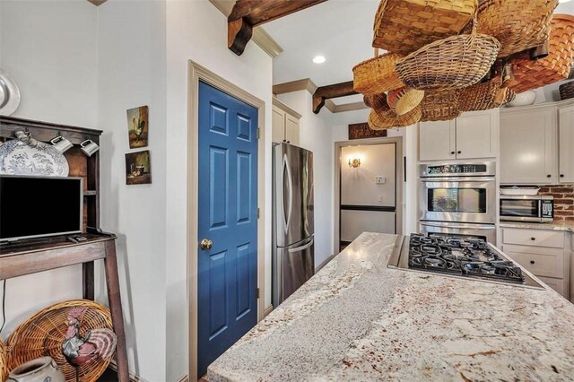 113 Cabretta Island Cir, Brunswick, GA 31520 - kitchen featuring beam ceiling, appliances with stainless steel finishes, white cabinetry, and light stone counters