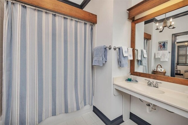 113 Cabretta Island Cir, Brunswick, GA 31520 - bathroom with a sink, baseboards, a notable chandelier, and tile patterned flooring