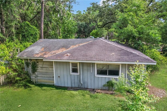 156 Lansing St, Brunswick, GA 31525 - view of side of property featuring a shingled roof, a lawn, and board and batten siding