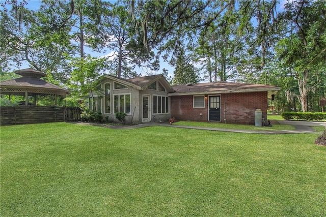 156 Lansing St, Brunswick, GA 31525 - back of property featuring a gazebo, a yard, and brick siding
