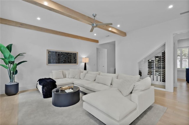 living room featuring ceiling fan, beamed ceiling, and light hardwood / wood-style floors