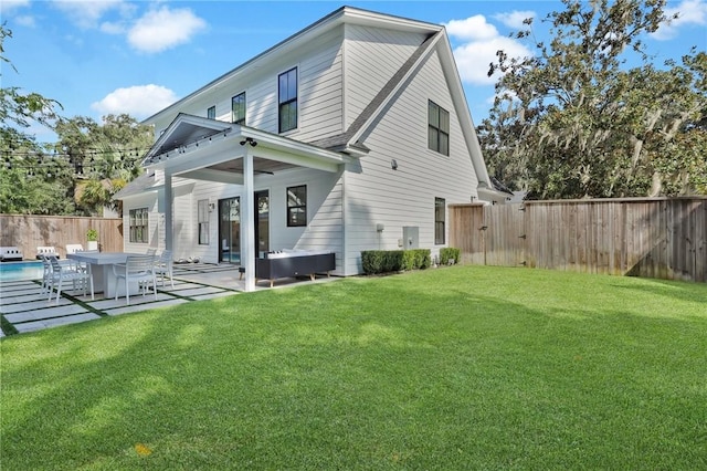 rear view of property with a patio and a lawn