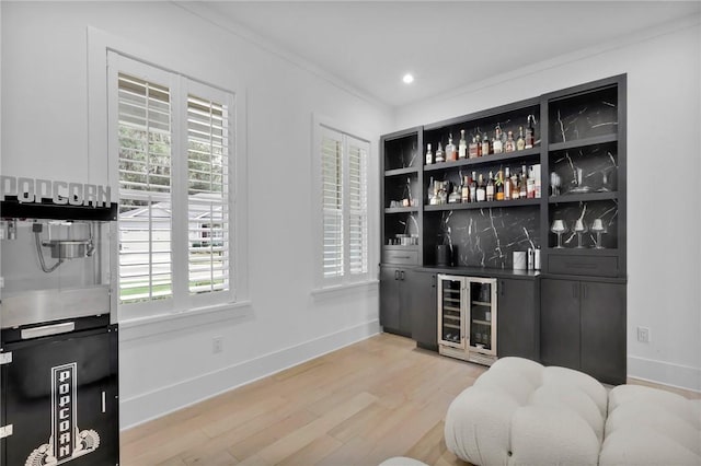 bar featuring hardwood / wood-style flooring, ornamental molding, and wine cooler