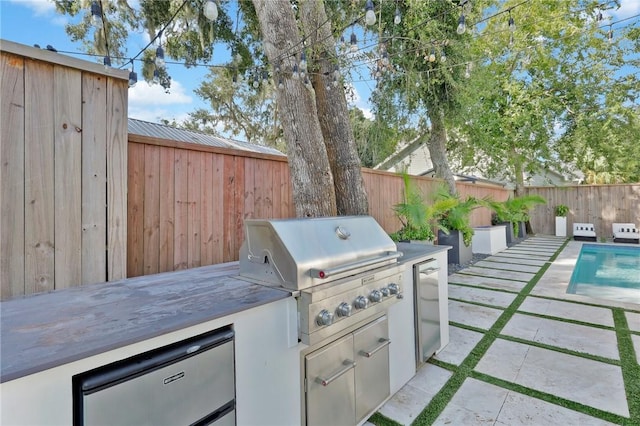 view of patio / terrace with an outdoor kitchen, a fenced in pool, and a grill