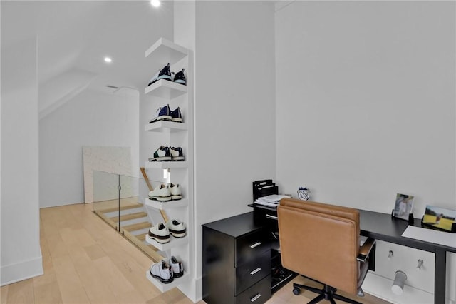 office space with built in shelves and light hardwood / wood-style flooring