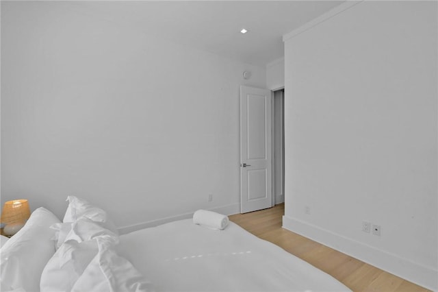 bedroom with light hardwood / wood-style flooring and ornamental molding