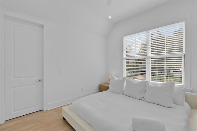 bedroom featuring ceiling fan, light hardwood / wood-style flooring, and vaulted ceiling