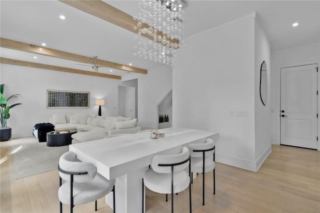 dining space with beamed ceiling, light hardwood / wood-style floors, and an inviting chandelier