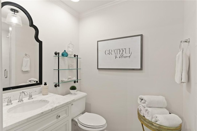 full bath featuring vanity, toilet, a shower with shower door, and ornamental molding