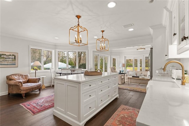 spacious closet featuring dark wood-style floors, a notable chandelier, visible vents, and a sink