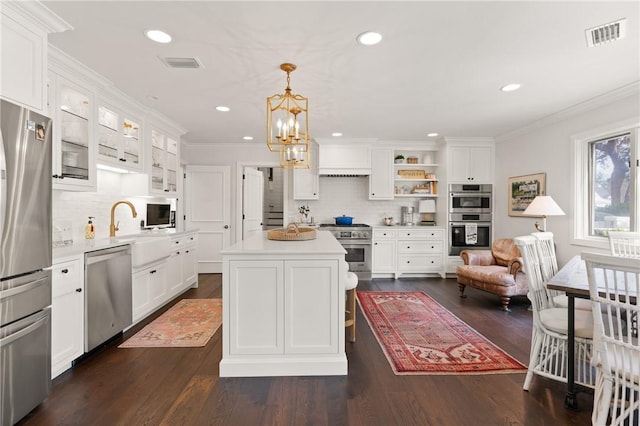 kitchen with visible vents, light countertops, appliances with stainless steel finishes, white cabinetry, and crown molding