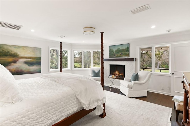 bedroom featuring visible vents, multiple windows, and wood finished floors