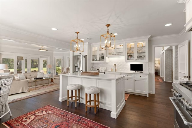 kitchen featuring white cabinets, stainless steel appliances, an inviting chandelier, and dark wood-style flooring