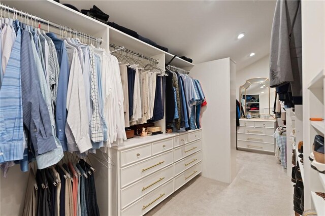 walk in closet with light colored carpet