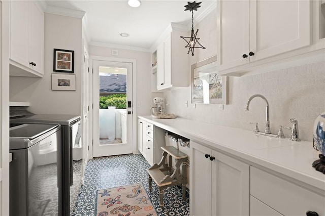 washroom with crown molding, separate washer and dryer, tile patterned floors, cabinet space, and a sink