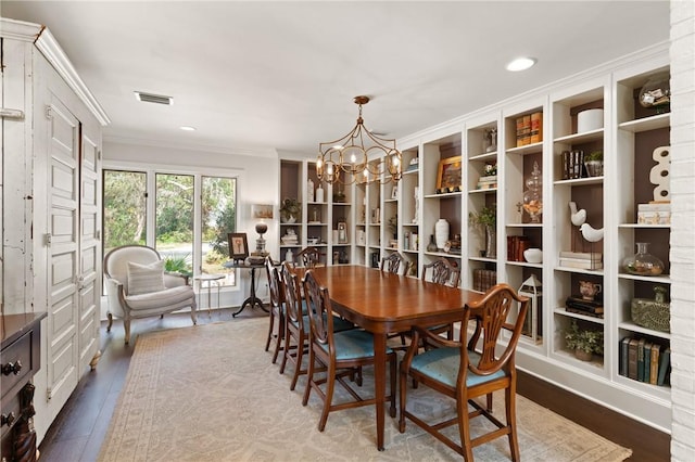 dining space featuring wood finished floors, visible vents, an inviting chandelier, recessed lighting, and crown molding